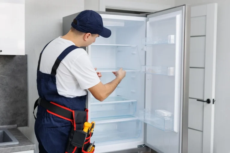 Professional refrigerator repair technician fixing cooling system in Beverly Hills Los Angeles home