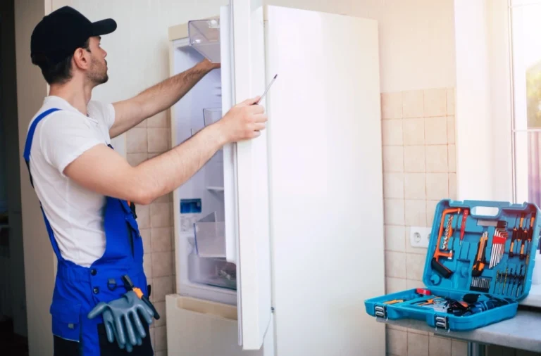 Emergency refrigerator repair technician responding to cooling failure in Los Angeles home during heat wave with diagnostic tools